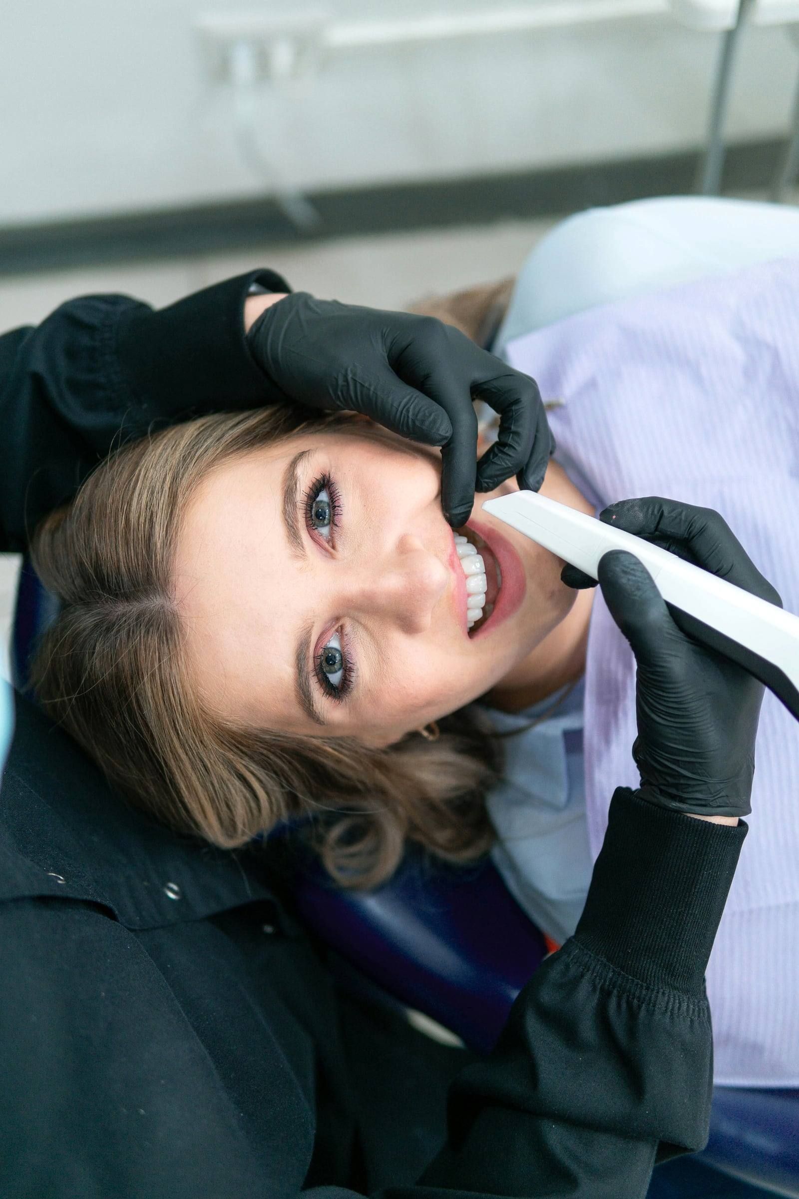 A patient smiling up from the dental chair during treatment.